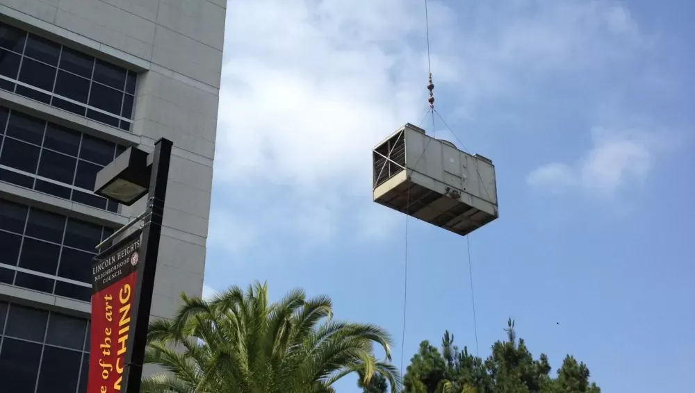 AC unit being lifted by crane