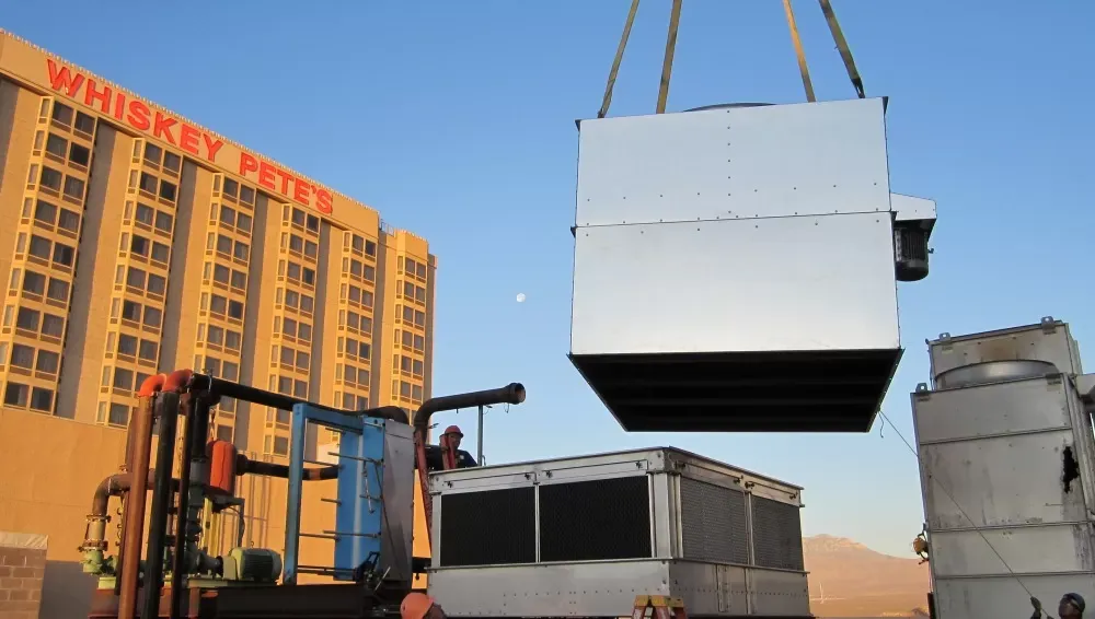 AC unit being lifted and installed