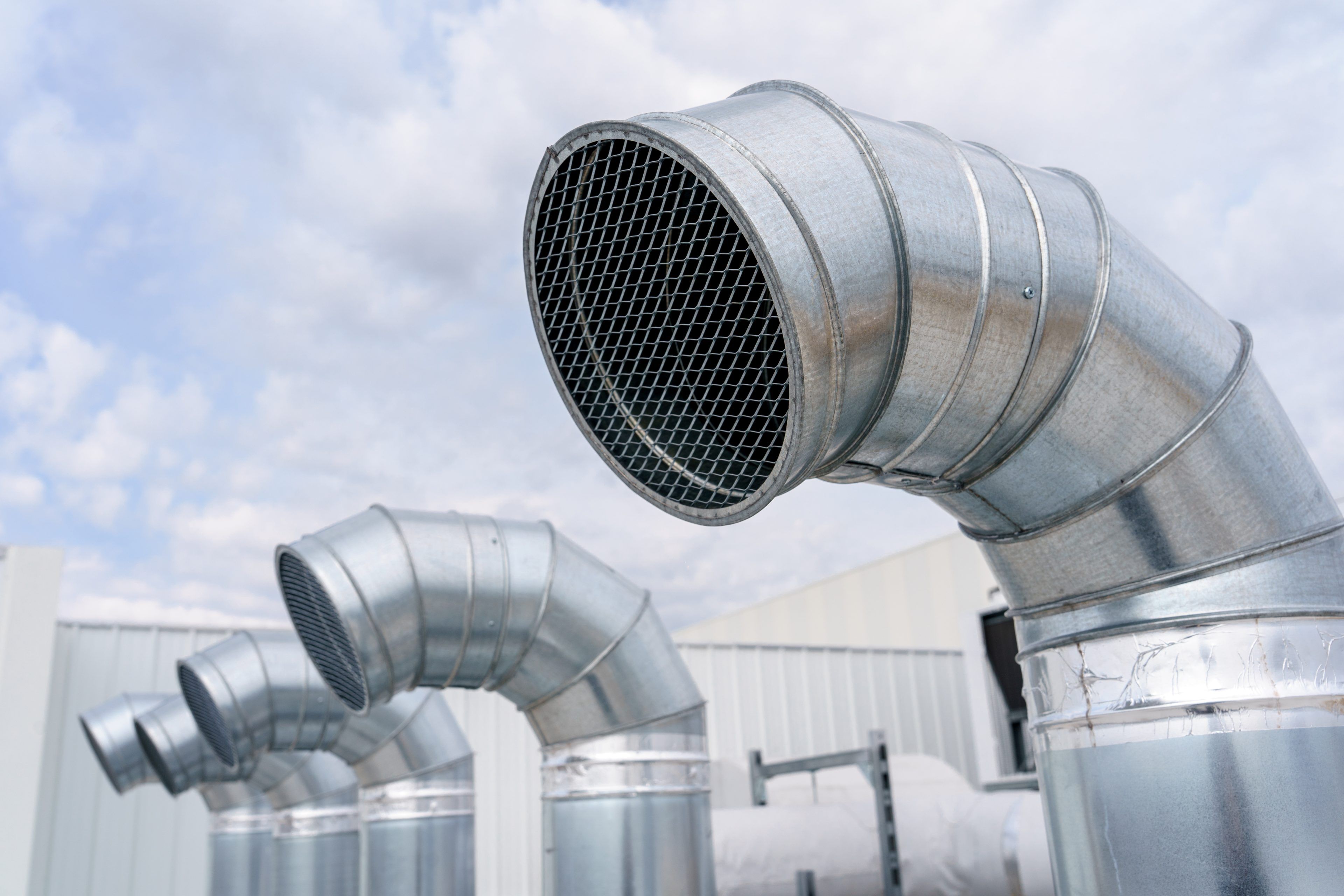 Close-up of a metal pipe duct. The air conditioning and ventilation system of a large industrial building is located on the roof. Air ducts, air conditioning, smoke removal and ventilation