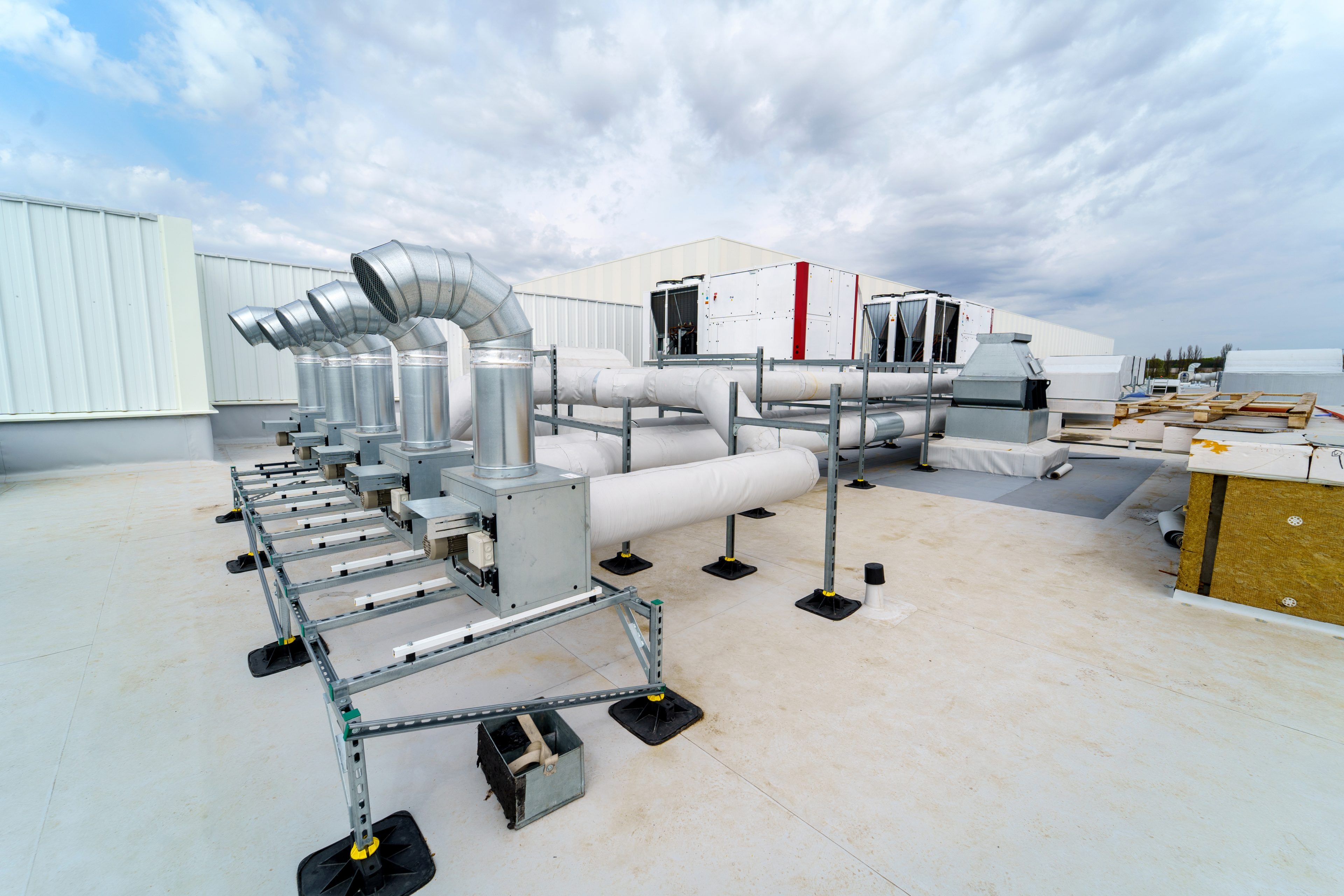 The air conditioning and ventilation system of a large industrial building is located on the roof. It consists of air ducts, air conditioning, smoke removal and ventilation