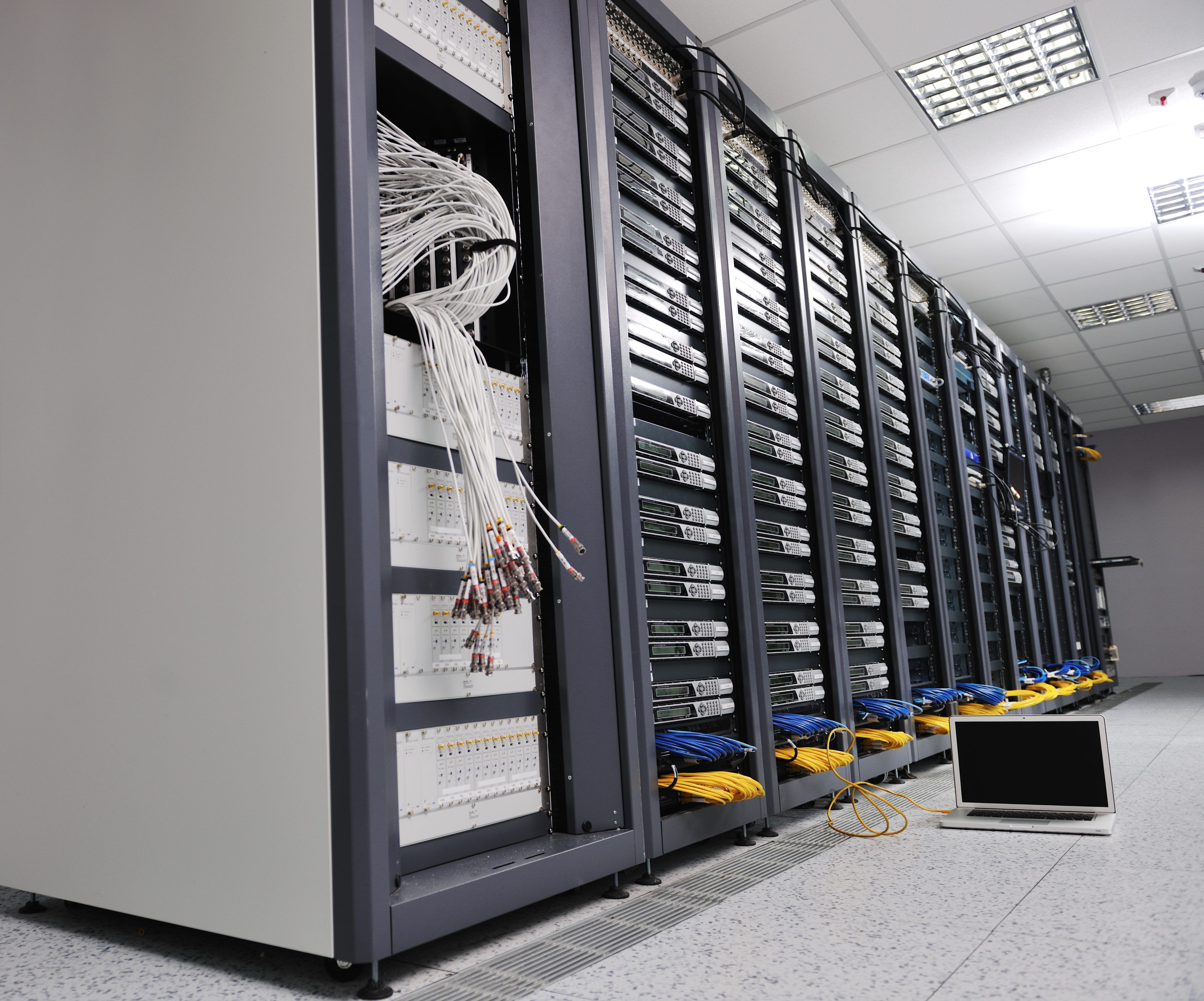 modern aluminium thin laptop computer at server network room representing concept of control and remote access and support
