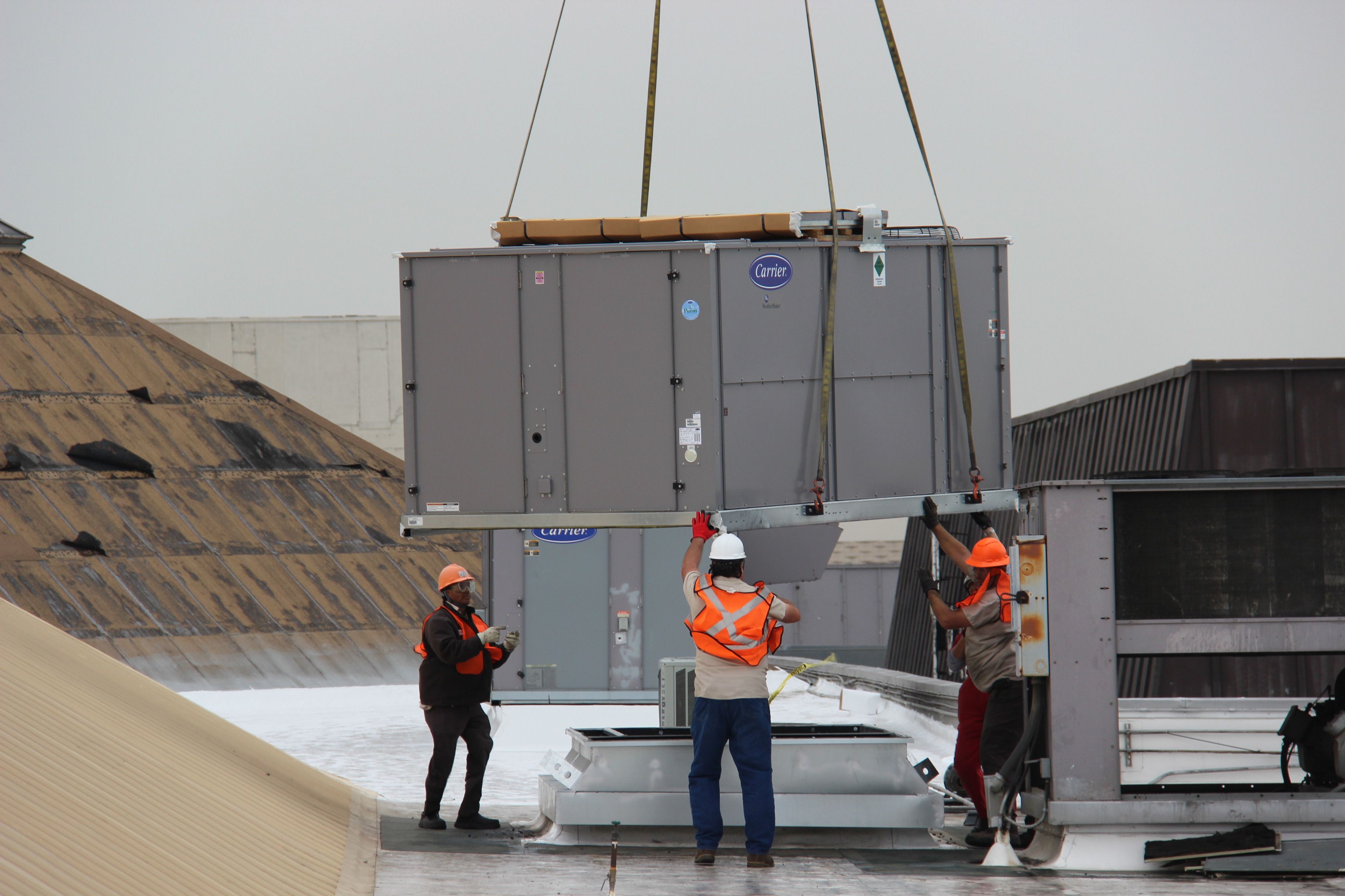 Workers installing a HVAC Unit