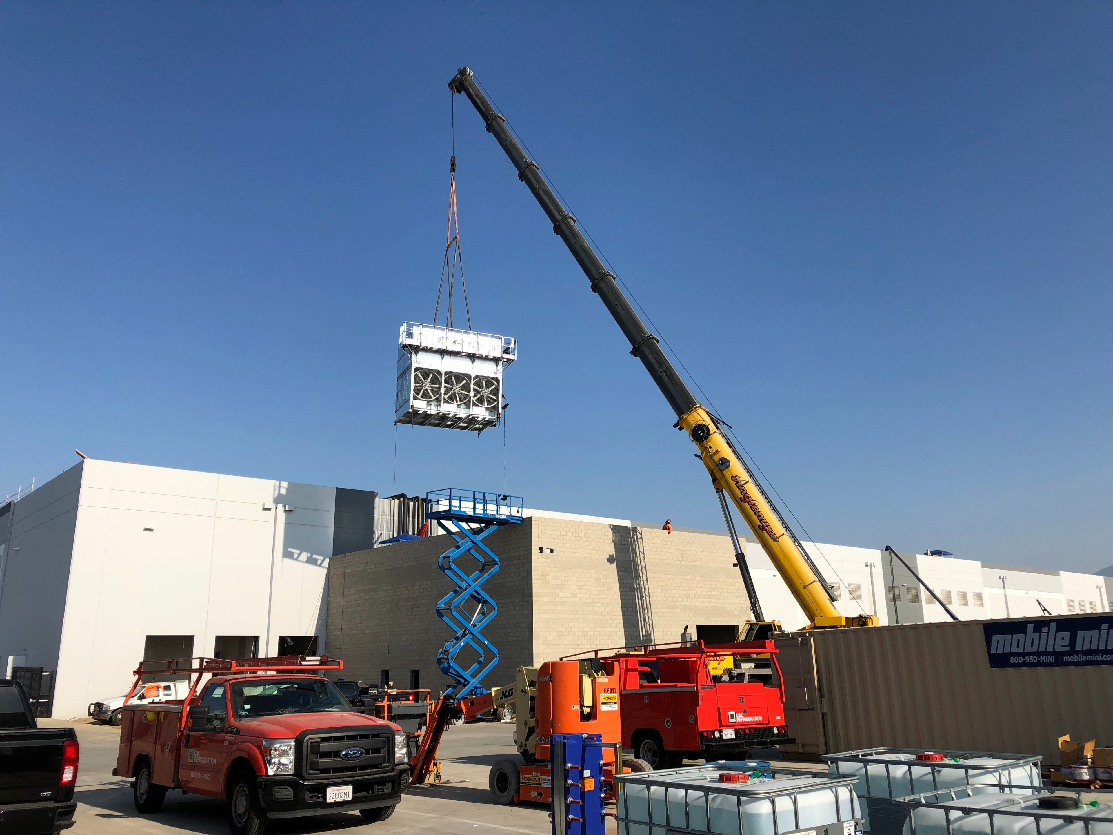 Crane lowering a refrigeration unit