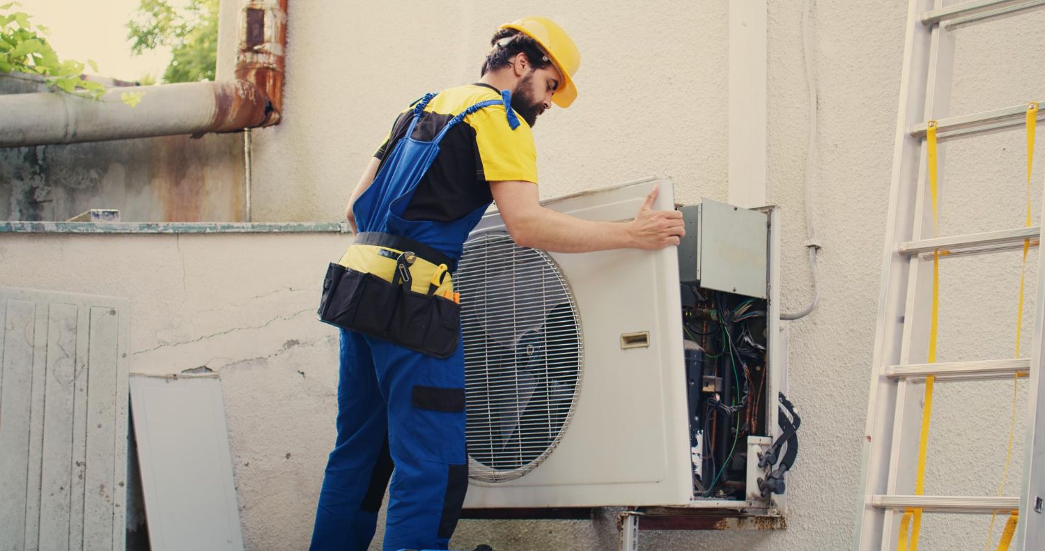 Worker opening up an AC